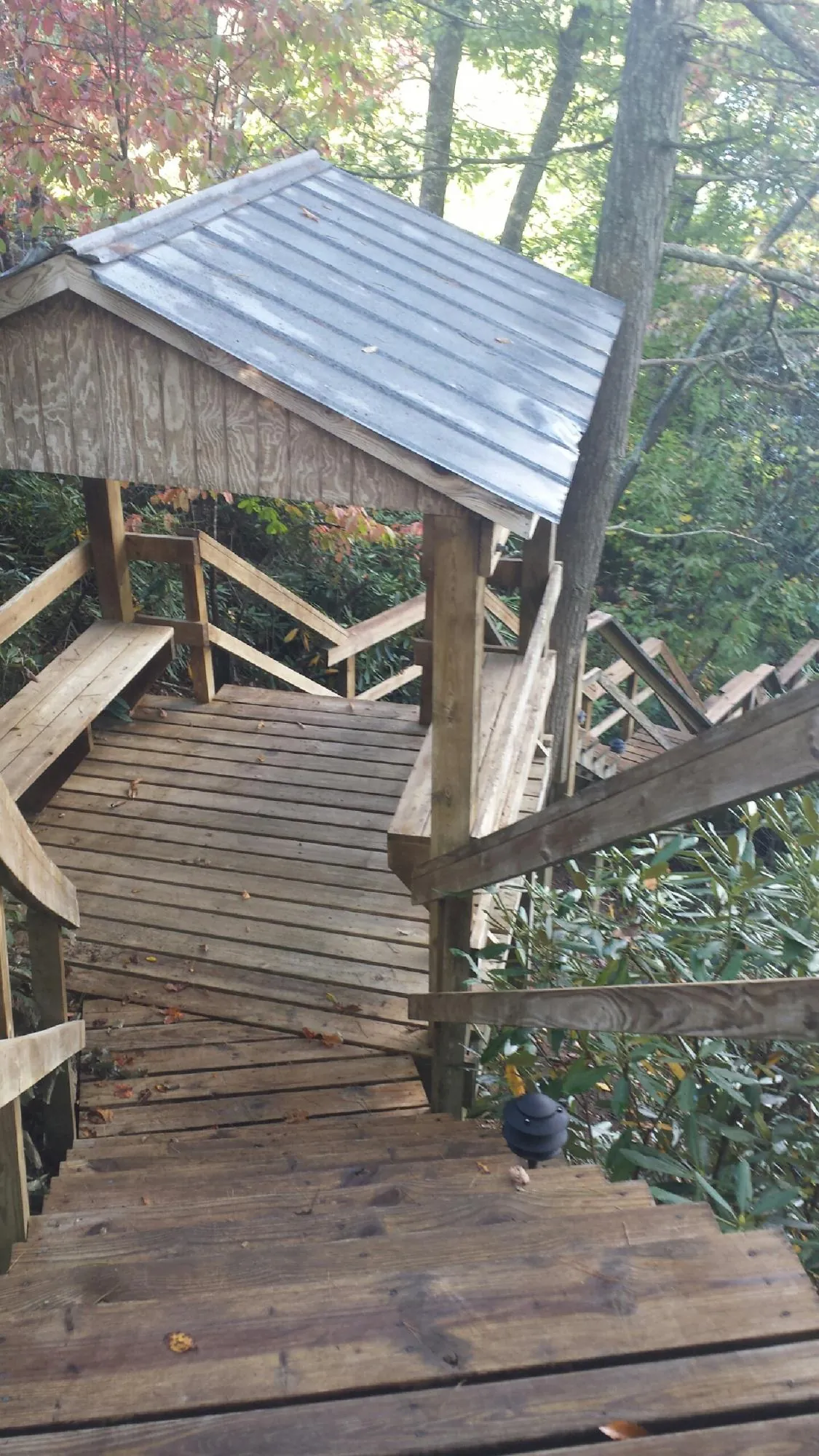 Metal roofed shelter over wooden steps on a wooded walkway — Skylight Repair & Installation work by our crew in Ashby