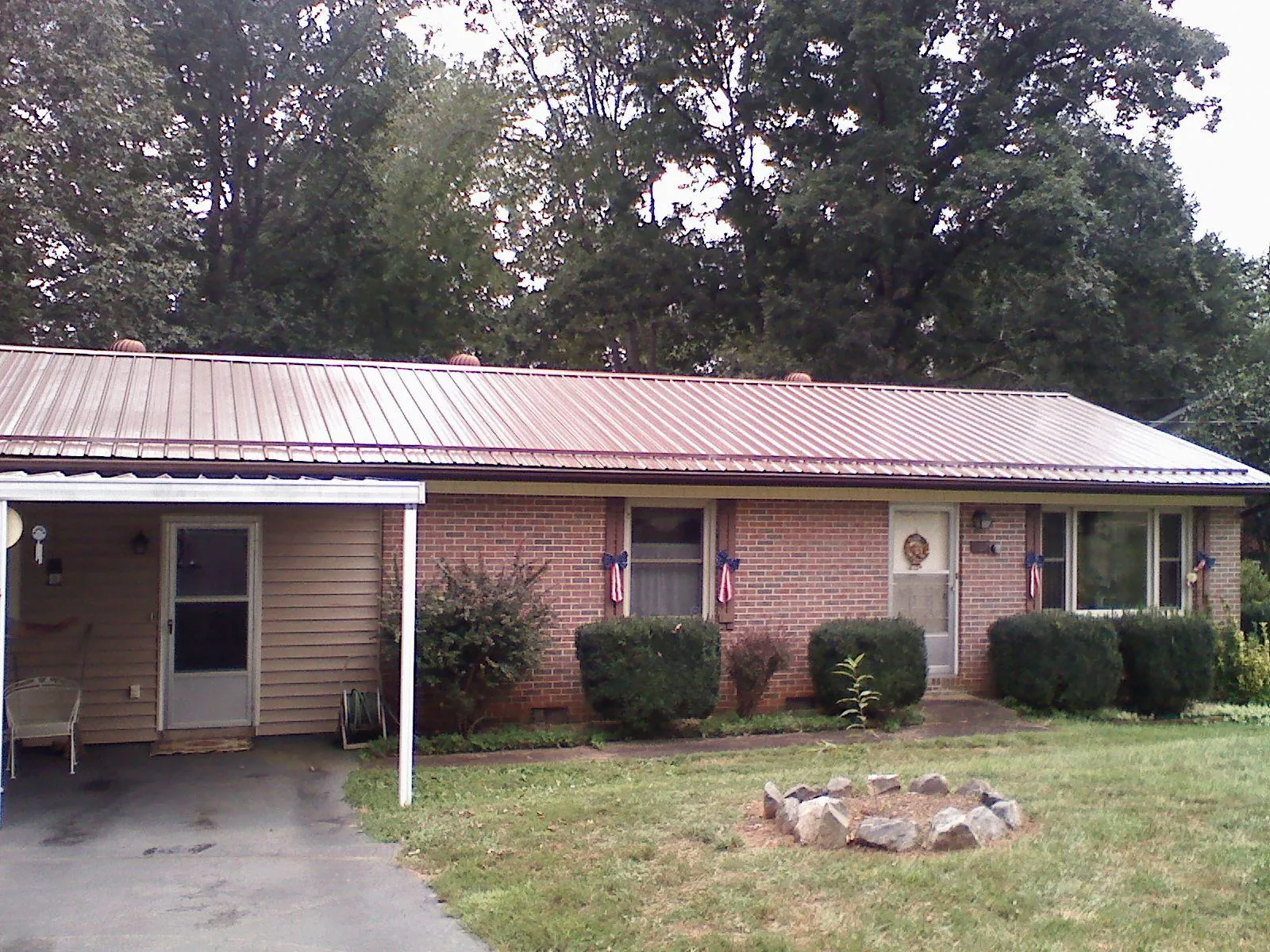 Bronze metal roof and carport on a brick ranch home — Roof Repair work by our crew in Ashby